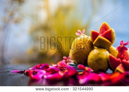 Raw Organic Guava Or Amrut Or Amarood In Hindi Language On Black Shinny Surface In A Blue-colored Pl