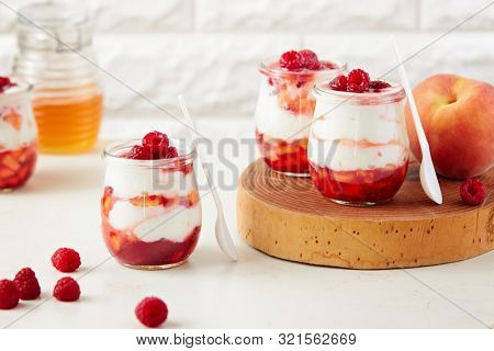 Homemade peach and raspberry dessert with yogurt cream