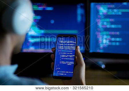 Software Developer Freelancer With White Headphones And Glasses Working With Program Code: C++ Java,