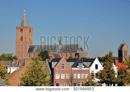 Historic Houses Located Inside The Fortified Town Of Naarden, Netherlands, With The Clock Tower Of T