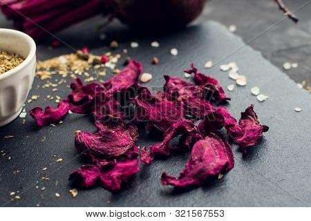 Healthy Homemade Vegetable Chips From Beetroot With Salt, Pepper And Origano On Black Background. Or