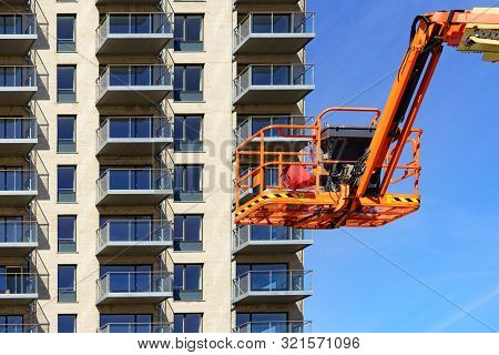 Basket Lift, Orange Lifting Platform On Construction Site. Industrial Machine, Work On Height Equipm