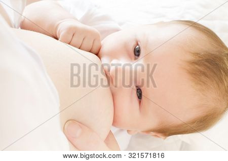 Baby Eating Breast Milk. Mother Breastfeeding Her Baby Boy. Concept Of Lactation.