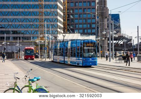 Stockholm, Sweden - April 18, 2019: Blue Tram, Red Cng Bus And Shared Bicycles As An Ecological Mean