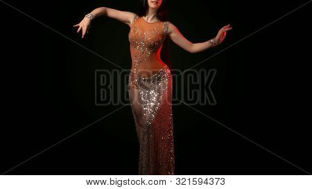The Body Of A Beautiful Girl In A Bead Costume For Belly Dance On A Black Background. Sexy Woman Dan