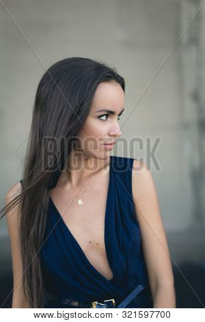 Closeup Portrait Of A Happy Young Brunette Teenage Girl Outdoor. Concrete Wall On Background