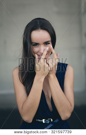 Closeup Portrait Of A Happy Young Brunette Teenage Girl Outdoor. Concrete Wall On Background