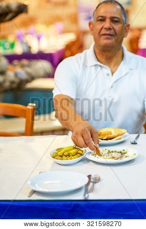 Senior Man Eat Labneh With Pita Bread. Labneh-soft Cheese, Similar In Texture To Cream Cheese, Made 