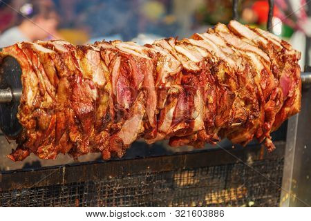 Large Pieces Of Meat On A Spit. Crilled Skewered Beef Meat On Spit. Traditional Meat Shaved. Fast Fo