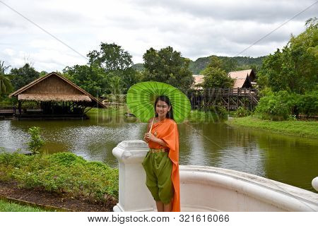 Kanchanaburi, Thailand, 09.09.2019: Beautiful Thai Girl In Traditional Thai, Siamese Dress With Gree