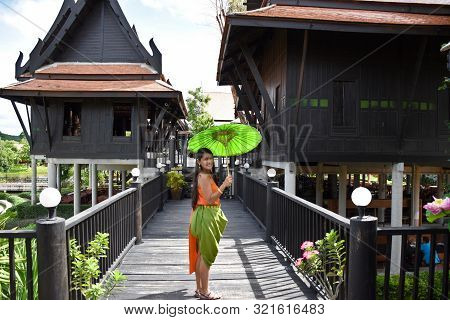 Kanchanaburi, Thailand, 09.09.2019: Beautiful Thai Girl In Traditional Thai, Siamese Dress With Gree