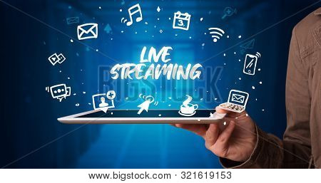 Young business person working on tablet and shows the inscription: LIVE STREAMING