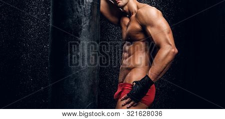Sexy Handsome Man With Beautiful Muscular Body And Mini Red Pants Is Posing On The Dark Background N