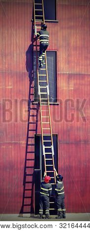 Fire Fighters At Firehouse And A Long Wodden Laddder With Old Toned Effect