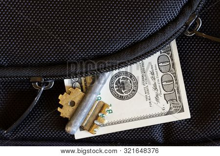 The Zipper On The Bag, Unbuttoned By The Thief, From Whose Pocket A Hundred-dollar Bill And Key Peep