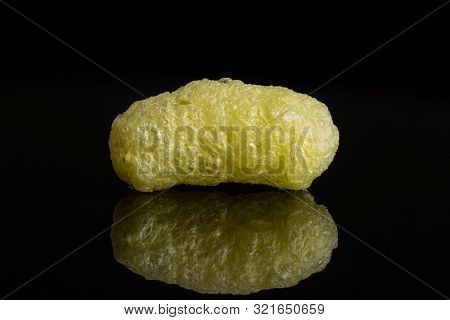 One Whole Salted Yellow Corn Puff Isolated On Black Glass