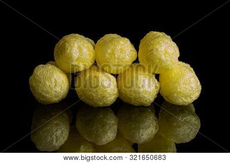 Group Of Seven Whole Salted Yellow Corn Puff Isolated On Black Glass