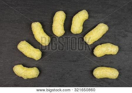 Group Of Eight Whole Salted Yellow Corn Puff Flatlay On Grey Stone