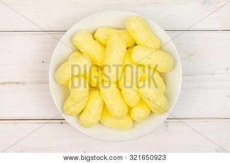 Lot Of Whole Salted Yellow Corn Puff On White Ceramic Plate Flatlay On White Wood