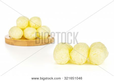 Group Of Eight Whole Salted Yellow Corn Puff On Bamboo Coaster Isolated On White Background