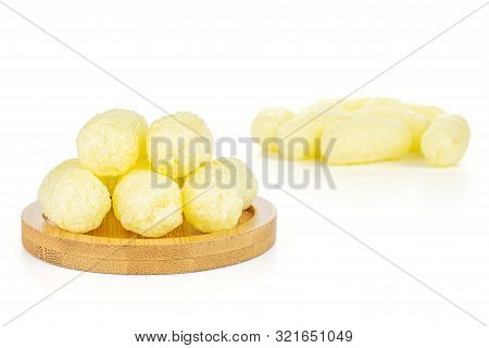 Lot Of Whole Salted Yellow Corn Puff On Bamboo Coaster Isolated On White Background