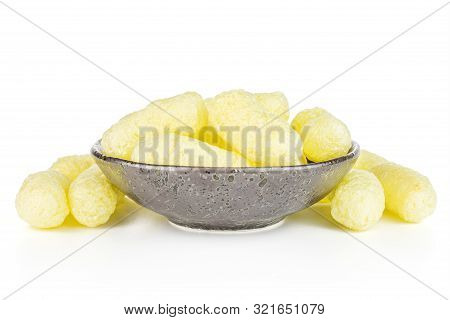 Lot Of Whole Salted Yellow Corn Puff In Dark Ceramic Bowl Isolated On White Background