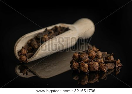 Lot Of Whole Dry Brown Clove Small Group Is Aside And The Rest Is In A Wooden Scoop Isolated On Blac