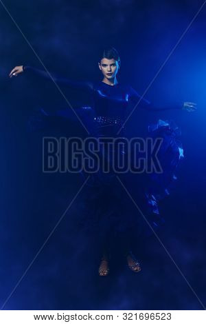 Beautiful girl performs Latino dance with expression. Professional dancer in motion. Beauty, fashion.