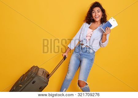 Close Up Portrait Of European Caucaian Female Dressed In Stylish Clothes Carries Suitcase With Airpl