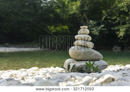 Harmony, Balance And Simplicity Concept. A Stone Pyramid On The Background Of River Water. Simple Po