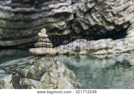 Harmony, Balance And Simplicity Concept. A Stone Pyramid On The Background Of River Water. Simple Po