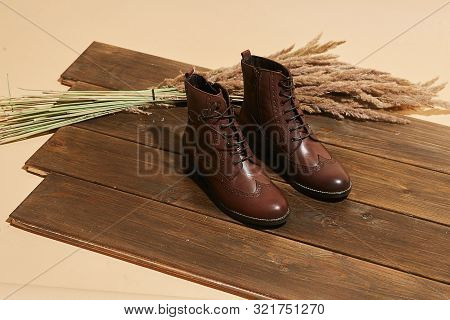 Stylish Fashion Shoes Boots Footwear Concept On Brown Wooden Background. Urban Footwear Advertising