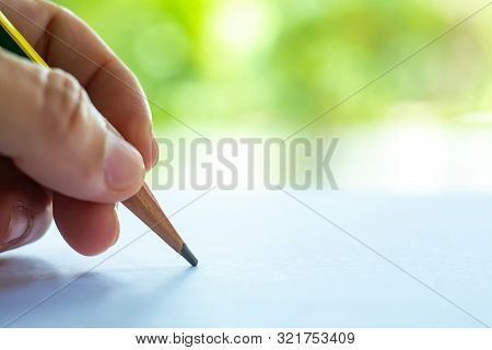 Woman's Left Hand Holding Multicoloured Pencil (yellow & Green Colour), Writing Letter On White Pape