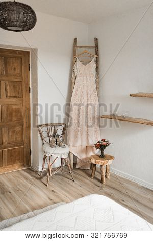 Wedding Interior. Charges The Bride At The Hotel. Wedding Photography. The Brides Dress Hangs Near T