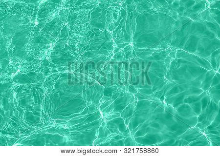 Closeup Of Calm Clear Water Surface With Water Splashes In Trendy Mint Color. Swimming Pool Water Te