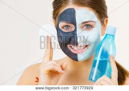 Woman With Clay Carbo Black Mask On One Half Face And White Mud On Second Half. Girl Removing Cosmet