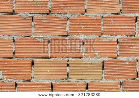 The New Corpulent Brick Wall Has An Orange Color And A Horizontal Texture With A Cement Seam.