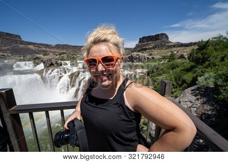 Blone Young Adult Woman Poses With Her Camera At The Overlook Of Shoshone Falls In Twin Falls Idaho