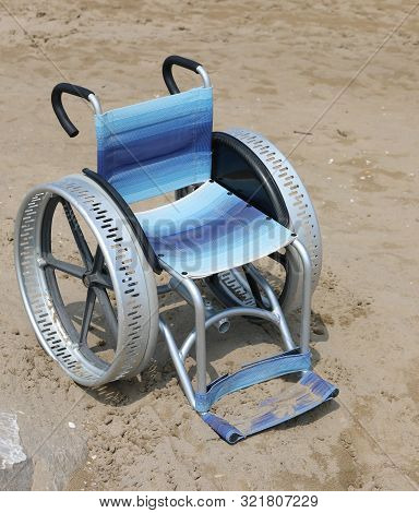 Wheelchair With Large Aluminum Wheels On The Sand Of The Beach Without Any Person