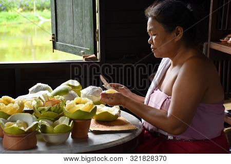 Kanchanaburi, Thailand, 09.09.2019: A Local Thai Woman In Traditional Thai, Siamese Dress Is Pealing