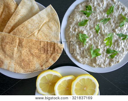 Famous Traditional Arabic Cuisine - Dip Baba Ganoush With Pita Bread And Fresh Lemon On Dark Wooden 