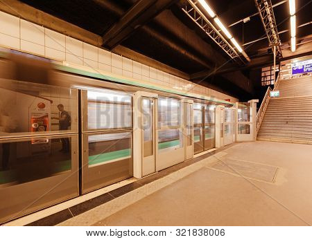 Paris, France - Jul 14, 2011: Fast Parisian Metro Train Passing Behind Security Barrier At The Platf