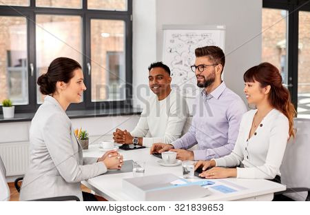 new job, hiring and employment concept - international team of recruiters having interview with female employee at office