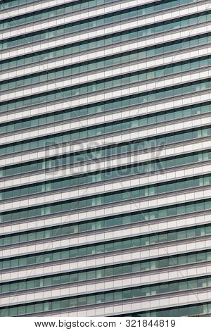 Glass windows and concrete walls in the daytime. Arcitectural fragment of modern building in Bangkok, Thailand.