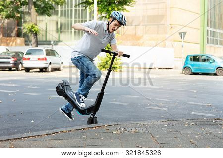Man Having Accident Falling From E-scooter On Street