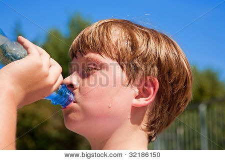 Junge trinkt Wasser aus der Flasche nach dem Sport