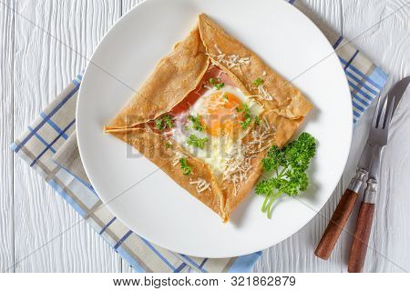 Breton Crepe, Savory Buckwheat Galettes Bretonnes With Fried Egg, Cheese, Ham Served On A White Plat