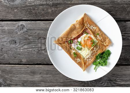 Breton Crepe, Savory Buckwheat Galettes Bretonnes With Fried Egg, Cheese, Ham Served On A White Plat