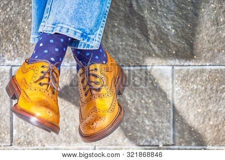 Closeup Of Mens Legs Wearing Brown Oxfords Semi Brogues Shoes. Posing Outdoors Against Stony Grunge 