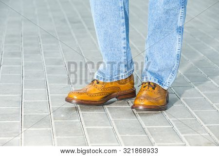 Closeup Of Male Legs Wearing Leather Brown Oxford Semi Brogues Shoes. Photographed In Motion. Horizo